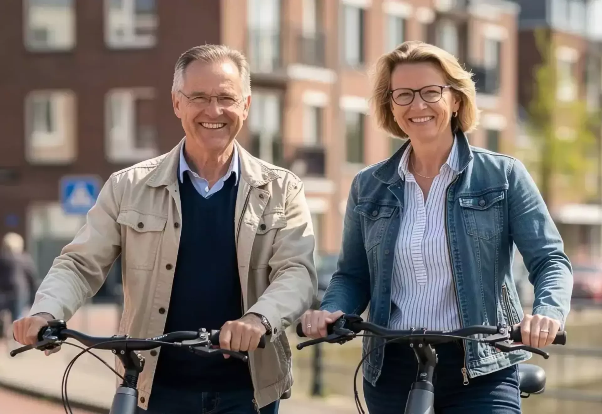 Een glimlachend stel fietst samen door een stad.